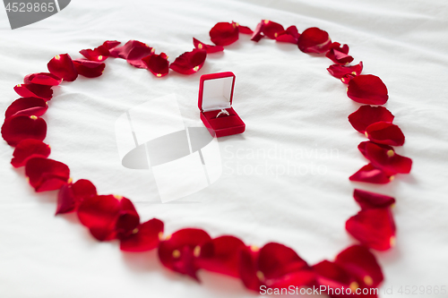 Image of heart made of petals and diamond ring in gift box