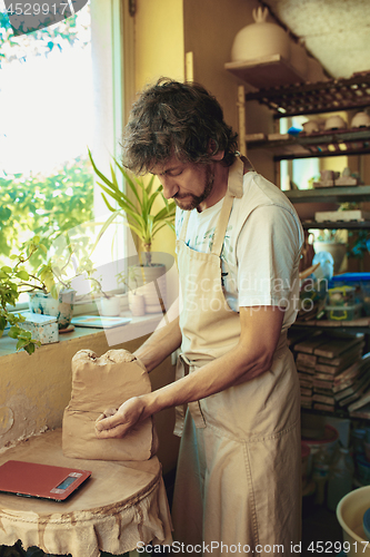 Image of Creating a jar or vase of white clay close-up. Master crock.