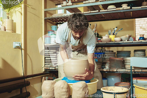 Image of Creating a jar or vase of white clay close-up. Master crock.