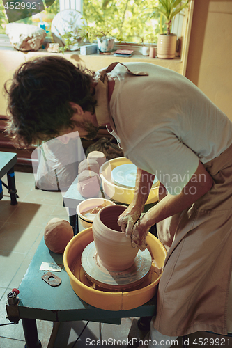 Image of Creating a jar or vase of white clay close-up. Master crock.