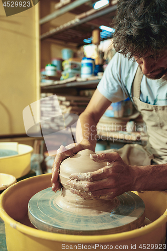 Image of Creating a jar or vase of white clay close-up. Master crock.