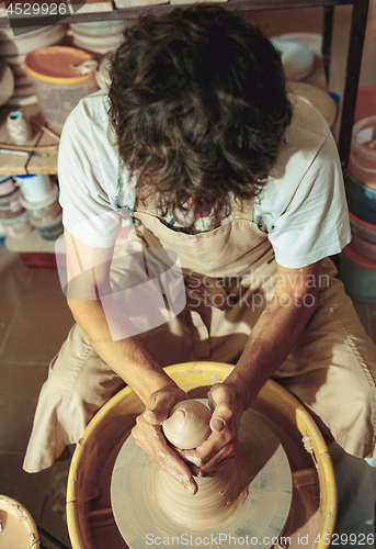 Image of Creating a jar or vase of white clay close-up. Master crock.