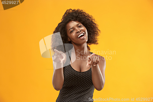 Image of The happy business woman point you and want you, half length closeup portrait on gold background.