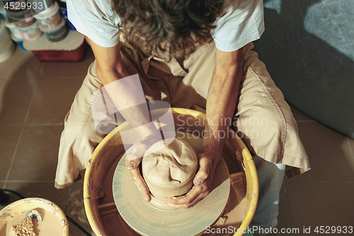 Image of Creating a jar or vase of white clay close-up. Master crock.