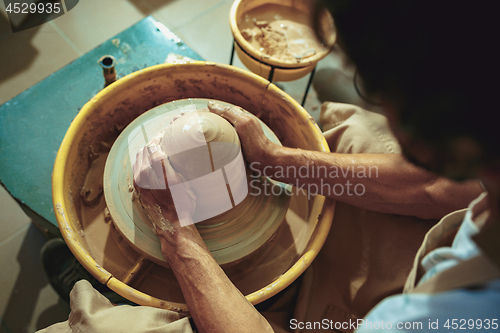 Image of Creating a jar or vase of white clay close-up. Master crock.