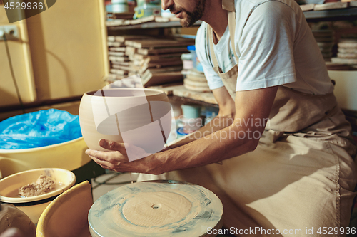 Image of Creating a jar or vase of white clay close-up. Master crock.