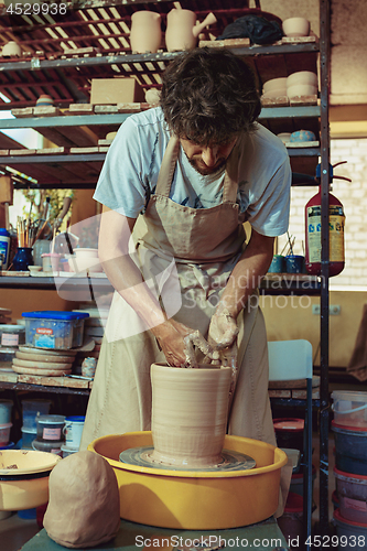 Image of Creating a jar or vase of white clay close-up. Master crock.