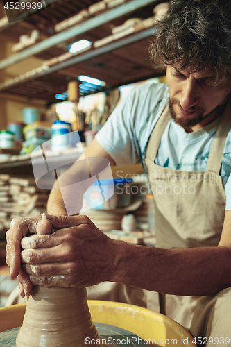 Image of Creating a jar or vase of white clay close-up. Master crock.