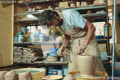 Image of Creating a jar or vase of white clay close-up. Master crock.