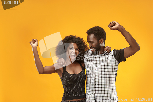 Image of Winning success couple celebrating being a winner. Dynamic energetic image of afro models