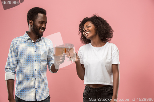 Image of The afro couple or happy young people laughing and drinking beer at studio