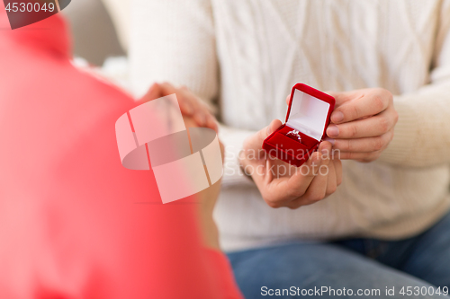 Image of man giving diamond ring to woman on valentines day