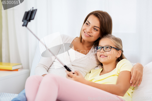 Image of happy family taking selfie by smartphone at home