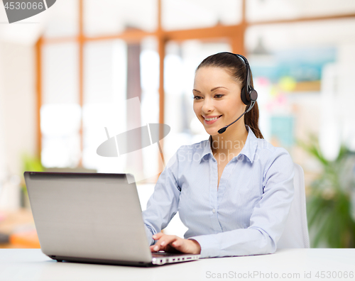 Image of helpline operator in headset working at office