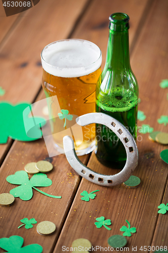 Image of glass of beer, bottle, horseshoe and gold coins