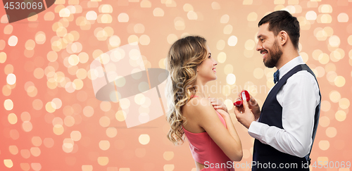 Image of man giving woman engagement ring on valentines day