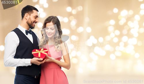 Image of happy couple with gift on valentines day