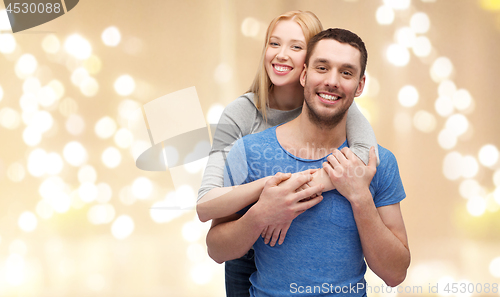 Image of smiling couple hugging over festive lights