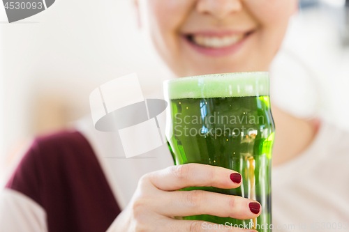 Image of close up of woman with green beer in glass