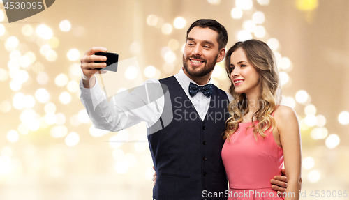 Image of happy couple taking selfie by smartphone
