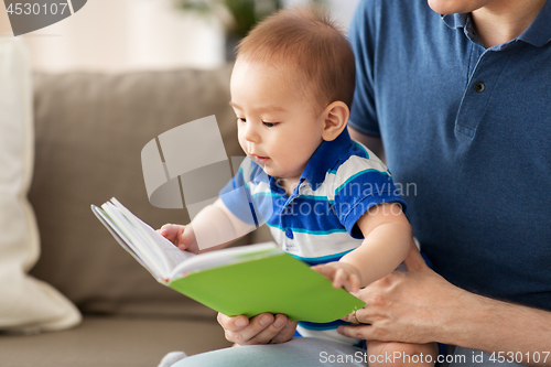 Image of baby boy and father with book at home