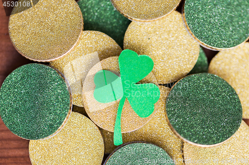 Image of close up of golden coins and green shamrock leaf