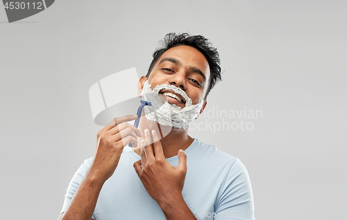 Image of indian man shaving beard with razor blade