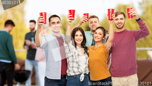 Image of group of friends toasting drinks at rooftop party