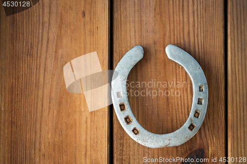 Image of old horseshoe on wooden background