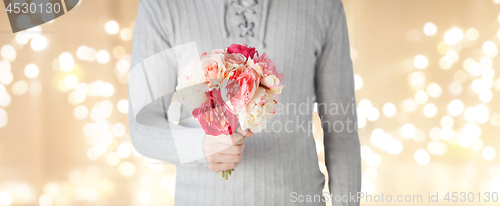 Image of close up of man holding flowers over lights