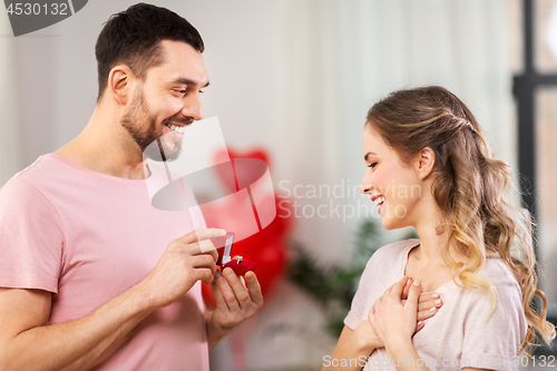 Image of man giving woman engagement ring on valentines day