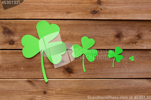 Image of green paper shamrocks on wooden background