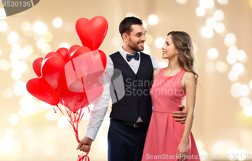 Image of happy couple with red heart shaped balloons