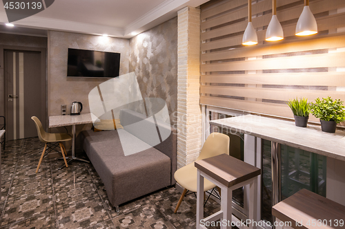 Image of The interior of a small living room in the hotel room, combined with kitchen