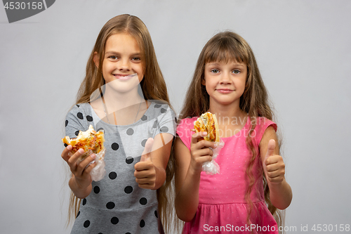 Image of Two girls eat bread and show class