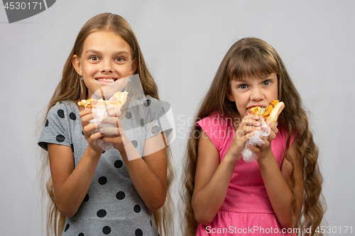 Image of Two girls are funny eating bread