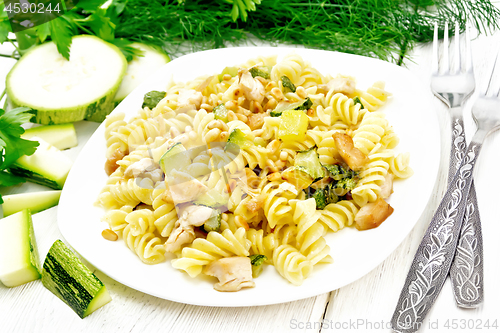 Image of Fusilli with chicken and zucchini in plate on board