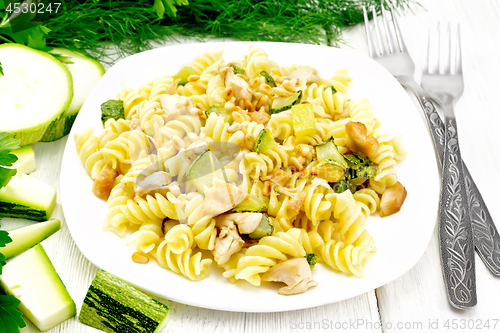 Image of Fusilli with chicken and zucchini in plate on white board