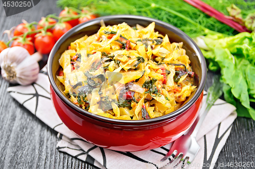 Image of Cabbage stew with chard in bowl on dark board