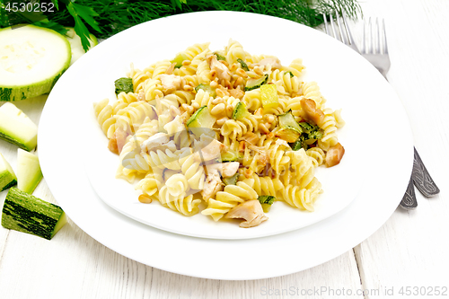 Image of Fusilli with chicken and zucchini in two plates on light board