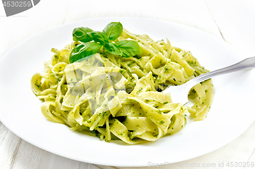 Image of Pasta with pesto sauce in plate on light board