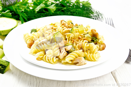 Image of Fusilli with chicken and zucchini in two plates on board