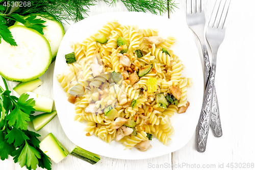 Image of Fusilli with chicken and zucchini in plate on board top