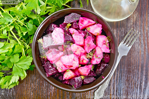 Image of Salad of beets and potatoes in bowl on dark board top