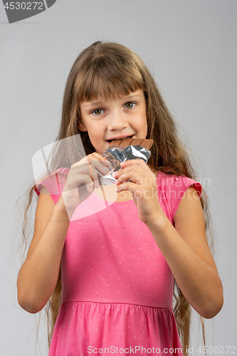 Image of Eight-year-old girl eats chocolate bar