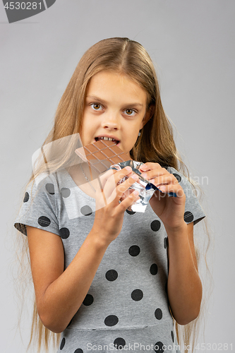 Image of A ten-year-old girl eats a chocolate bar