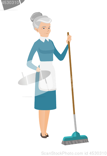 Image of Senior housemaid sweeping floor with a broom.