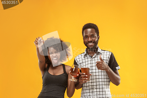 Image of The afro couple or happy young people laughing and drinking beer at studio