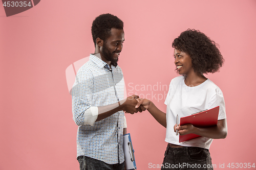 Image of Two african students with folders in t-shirts together. Stylish girl with Afro hairstyle and her boyfriend.