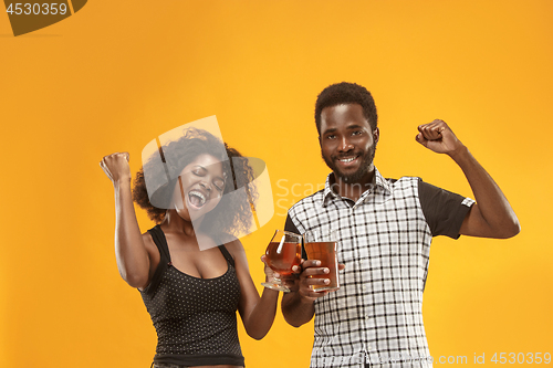 Image of The afro couple or happy young people laughing and drinking beer at studio